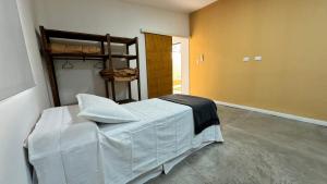 a bedroom with a bed with white sheets on it at Complejo La Mística in Copacabana