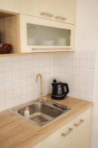 a kitchen counter with a sink and a microwave at Apartman Barbara in Lipany +47 photos