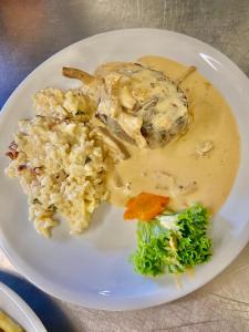 a plate of food with chicken and rice and broccoli at Gasthaus Adler Weilheim, Waldshut in Weilheim