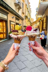 two people holding ice cream cones on a street at Suite Old Town Sorrento in Sorrento