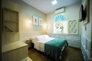 a small bedroom with a bed and a window at Pousada João e Maria Gramado in Gramado