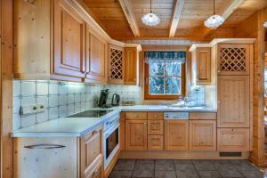 a kitchen with wooden cabinets and a sink at Haus Karin in Heiligenblut +27 photos