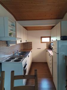 a kitchen with a white stove and a refrigerator at The red cottage in Kumlinge in Kumlinge