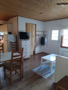 a living room with a table and a refrigerator at The red cottage in Kumlinge in Kumlinge +3 photos