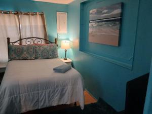 a bedroom with a bed and a picture of the beach at GpL 4134 Cozy & Spacious 4BR Shared House in Fort Myers