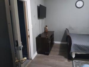 a bedroom with a bed and a dresser and a clock at GpL 4134 Cozy & Spacious 4BR Shared House in Fort Myers