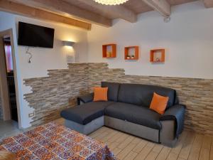 a living room with a couch and a brick wall at Chalet Val Concei in Lenzumo di Concei