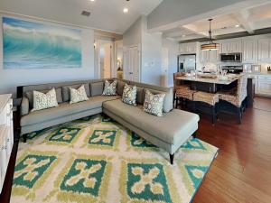 a living room with a couch and a kitchen at Beachfront Blue in Galveston