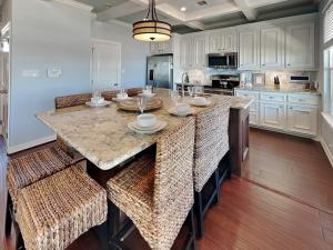 a kitchen with a large island with bar stools at Beachfront Blue in Galveston