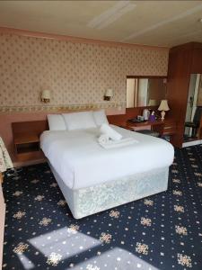 a bedroom with a large white bed in a room at The Limes Hotel in Market Rasen