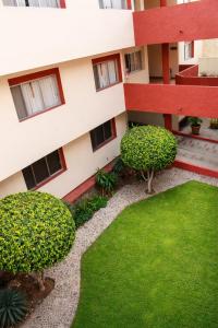anterior view of a building with a lawn and bushes at Hotel Acámbaro Plaza in Acámbaro