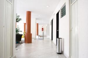 a hallway of a building with white walls and columns at Hotel Acámbaro Plaza in Acámbaro