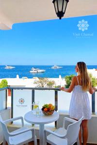 a woman standing on a balcony looking out at the ocean at Visit Chamal - Horizon View in Oued Laou
