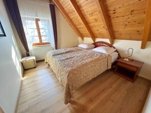 a bedroom with a bed and a wooden ceiling at Vila Banga in Nida