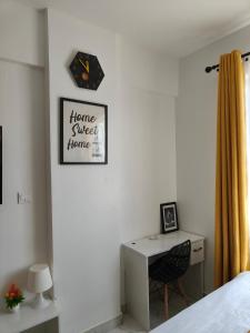 a bedroom with a desk and a clock on the wall at Heritage Homes in Ruiru