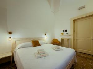 a bedroom with a white bed with two towels on it at Moro Guest House in Lecce
