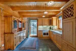 a large kitchen with wooden walls and wooden cabinets at Haus Karin in Heiligenblut