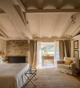a bedroom with a bed and a chair and a window at Hotel Finca El Peregrino in Puente la Reina +78 photos