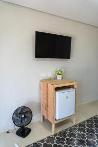 a room with a television on a wall with a fan at Suíte - Top Country Ranch in Boituva