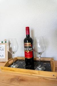 a bottle of wine and two wine glasses on a tray at Suíte - Top Country Ranch in Boituva