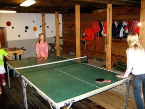 two girls standing around a ping pong table at Forest Retreat w Sauna in Sysslebäck