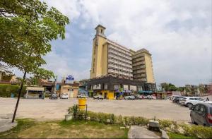 a large building with a clock tower in a parking lot at Hotel Lotus Paradise in Sonīpat