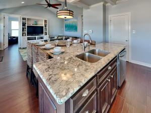 a kitchen with a sink and a counter top at Beachfront Blue in Galveston +23 photos