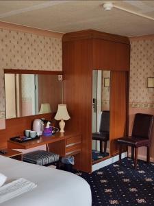 a hotel room with a bed and a desk and chair at The Limes Hotel in Market Rasen +11 photos