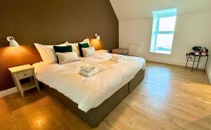 a bedroom with a large bed with white sheets at Northstar - 4 Bed Luxury Apartment by Together Travel in John O Groats