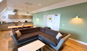 a living room with a couch and a kitchen at Northstar - 4 Bed Luxury Apartment by Together Travel in John O Groats