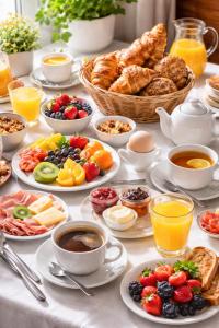 a table with plates of breakfast foods and cups of coffee at The Sisters Landeskogen in Grendi