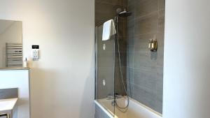 a bathroom with a shower with a bath tub at Northstar - 4 Bed Luxury Apartment by Together Travel in John O Groats +10 photos