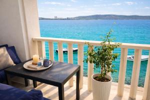 a table on a balcony with a view of the ocean at Stella Apartments in Kaštela