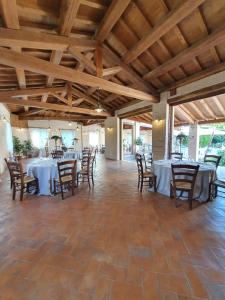 a dining room with tables and chairs and wooden ceilings at Albergo Diffuso La Piana dei Mulini in Colledanchise