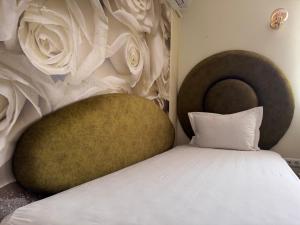 ein Schlafzimmer mit einem Bett und einer Wand mit Blumen in der Unterkunft Hotel Dafi in Plowdiw