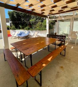 a wooden table and benches on a patio at Native Surfhouse in Praia da Areia Branca