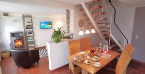 a dining room with a table and a staircase at Ferienhaus Ostseebrise Usedom im Grünen familienfreundlich ruhig Parkplatz Terrasse Kamin in Karlshagen