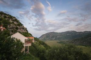 a view of a valley with a church and mountains at Apartment Village house in Ravno