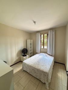 a bedroom with a bed and a window at Econômica Joinville Hostel e Pousada in Joinville