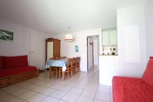a living room and kitchen with a table and chairs at Swing Moliets - T2 bis - Golf - 3 Piscines - Plage in Moliets-et-Maa