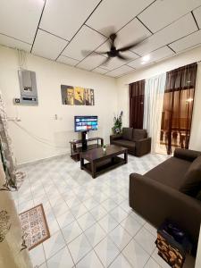 a living room with a couch and a tv at NorvillaA Pantai Cenang in Pantai Cenang