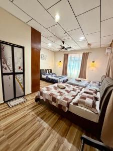 a room with two beds and a couch in it at NorvillaA Pantai Cenang in Pantai Cenang
