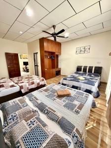 a room with three beds and a ceiling at NorvillaA Pantai Cenang in Pantai Cenang