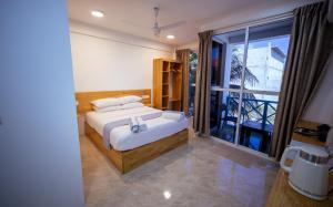 a bedroom with a bed and a large window at Buceo Inn Mathiveri in Mathiveri +70 photos