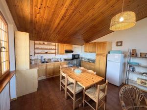 a kitchen with a wooden table and a white refrigerator at Ca' di Romagna B&B in Civitella di Romagna