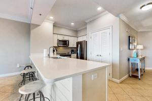 a kitchen with a white counter and a refrigerator at TOPS'L Tides in Destin +24 photos