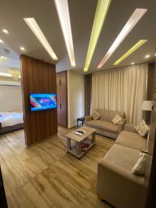 a living room with a couch and a tv at AlQimah Hotel Apartments in Amman