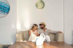 a man and a woman sitting on a couch at Hotel Lido Torre Egnazia in Monopoli