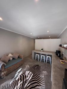 a living room with a couch and a zebra rug at LuVic Guesthouse in Naboomspruit
