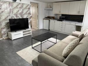 a living room with a couch and a tv and a table at Cosy Family Basement Apartment in Copenhagen Søborg with Jacuzzi in Søborg